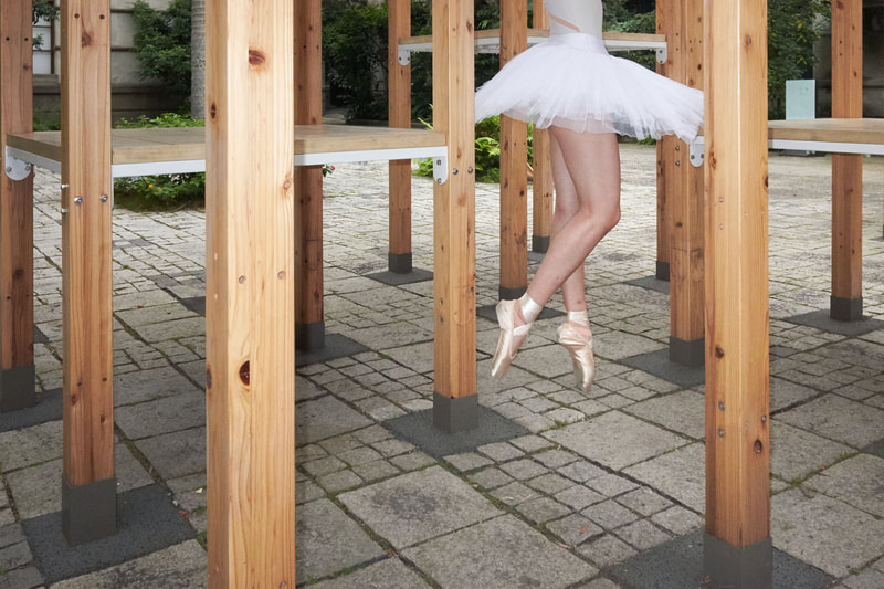 a photo of a ballerina in the air, shot by Kuo Chiao Lin on the Fujifilm XF10 model