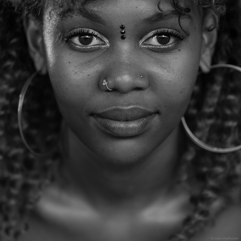 a close up photo of a lady with a nose ring and big hoop earrings, shot by Leon Oosthuizen on the Fujifilm GFX 50R camera model